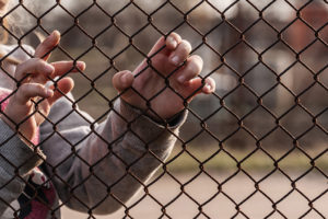 child refugee at fence